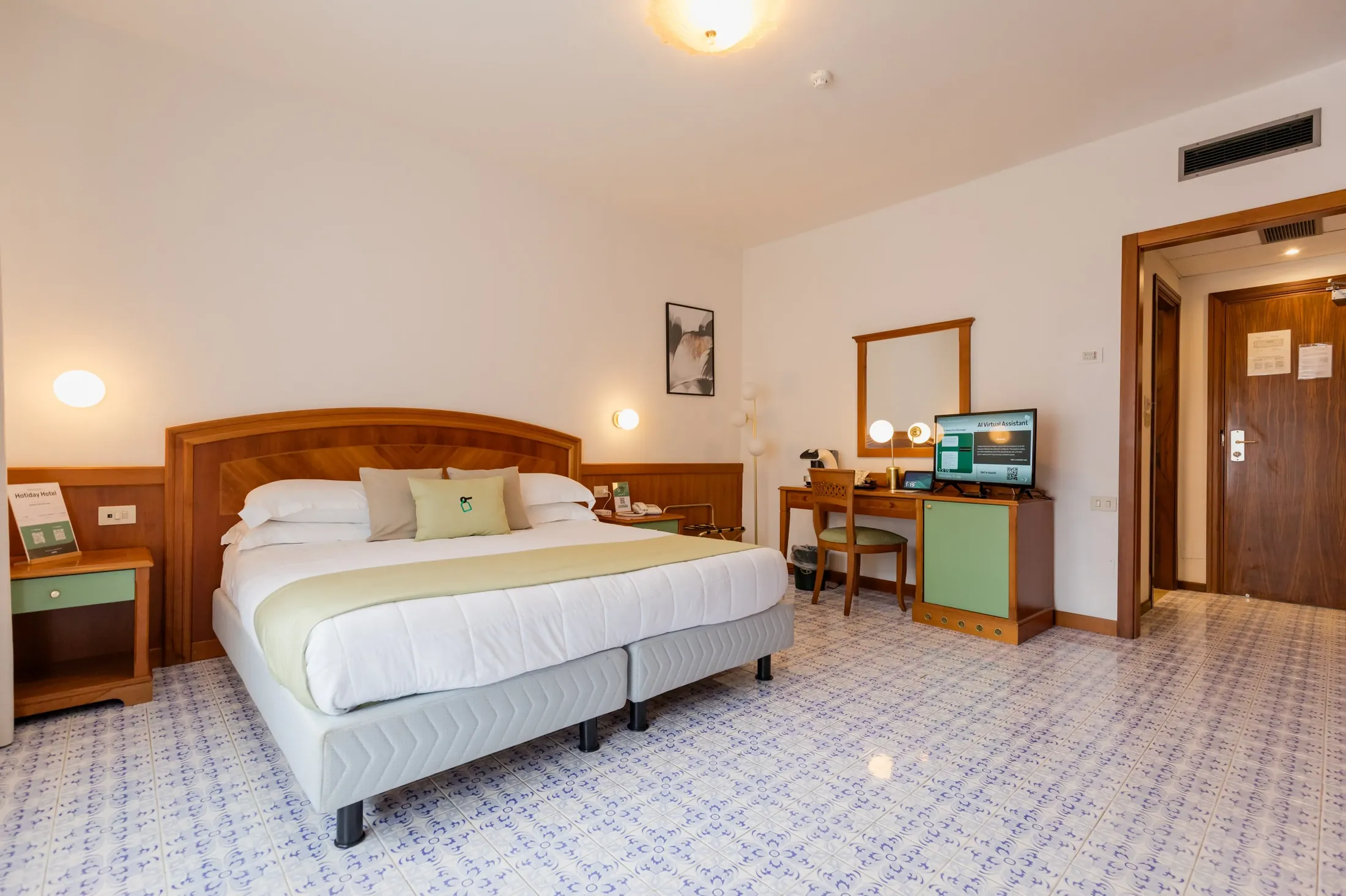 Camera d’albergo con letto matrimoniale, scrivania, TV e bagno privato aperto sulla destra